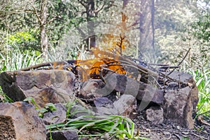 Natural barbecue with stones and branches fire.