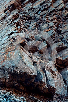 Natural basalt rock with cracks and crevices with a red color coming from iron