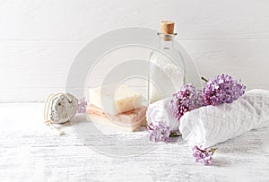 Natural bath salt, soap, cotton towels and lilac flowers symbolic image