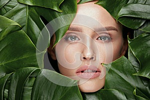 Natural Beauty. Beautiful Woman Face In Green Leaves.