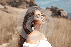 Natural beauty brunette outdoor portrait. Beautiful young bride woman with long wavy hair enjoying in the hay field.  Romantic