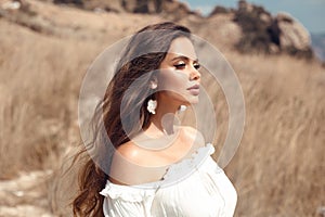 Natural beauty brunette outdoor portrait. Beautiful young bride woman with long wavy hair enjoying in the hay field.  Romantic