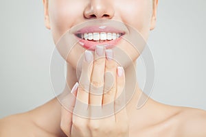 Natural beauty concept. Closeup female smile with natural pink lips and french manicure hand