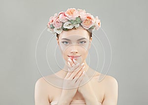 Natural beauty. Cute woman with healthy skin, manicured nails and roses flowers wreath