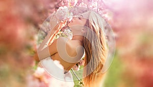 Natural beauty face. Outdoor fashion photo of beautiful young woman in flowers. Sensual girl on spring blossom