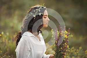 Natural beauty girl with bouquet of flowers outdoor in freedom enjoyment concept. Portrait photo