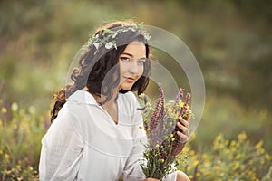 Natural beauty girl with bouquet of flowers outdoor in freedom enjoyment concept. Portrait photo