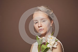 Natural beauty. Healthy woman with white flowers on brown background