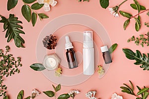 natural beauty, skincare, and cosmetic product with leaves and flowers on flat lay background