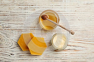 Natural beeswax, cream and honey on white wooden table, flat lay