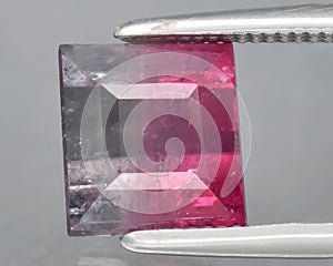 natural bi color tourmaline gem on the background