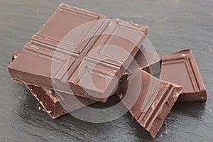 Natural bitter chocolate pieces on slate plate background