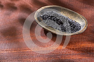 Natural black salt from Hawaii on wooden background