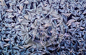 natural blue textured background with frosty pattern on glass on a clear winter morning