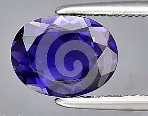 natural blue violet iolite gem on the background
