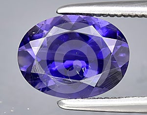 natural blue violet iolite gem on the background
