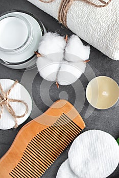 Natural body care cosmetics on concrete background. Spa accessories, towel, hairbrush, essential oil.