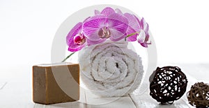 Olive oil soap, rolled towel and orchids for healthy purity photo