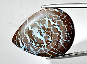 Natural boulder multi color opal gem on the background