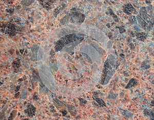 Natural brown granite with black splashes, closeup texture of dark stone