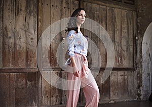 Natural brunette lady posing in front of the wooden gate