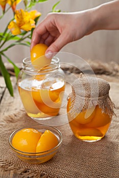 Natural canned peaches in glass jars with compote