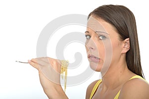 Natural Cautious Young Woman Holding A fork Full of Cooked Spaghetti Pasta