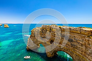 Natural caves at Marinha beach, Algarve Portugal. Rock cliff arches on Marinha beach and turquoise sea water on coast of Portugal