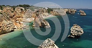 Natural caves at Marinha beach, Algarve Portugal. Rock cliff arches on Marinha beach and turquoise sea water on coast of Portugal