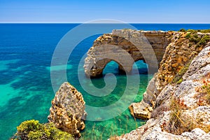 Natural caves at Marinha beach, Algarve Portugal. Rock cliff arches on Marinha beach and turquoise sea water on coast of Portugal