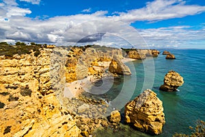 Natural caves at Marinha beach, Algarve Portugal. Rock cliff arches on Marinha beach and turquoise sea water on coast of Portugal