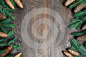 Natural Christmas background, brown wooden texture decorated with fir branches and cones