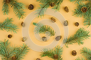 Natural christmas pattern from fir twigs and cones on beige background. Evergreen needles backdrop