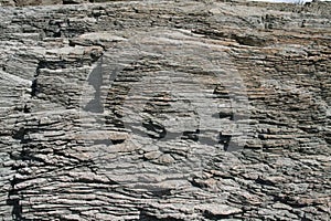 Natural coastal rock formation surface rough material close up textured wall