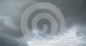 Natural color dramatic dark blue cloudy sky with wavy rippling clouds aligned above horizon, taken with wide angle 35 mm lens