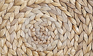 Natural color straw mat surface with round pattern.