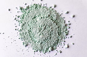 Natural colored pigment powder close up, matt pastel green eyeshadow or powder mica pigment on a white background photo