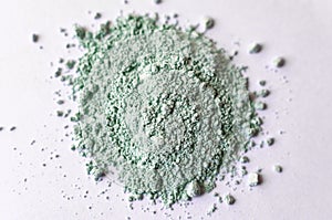 Natural colored pigment powder close up, matt pastel green eyeshadow or powder mica pigment on a white background