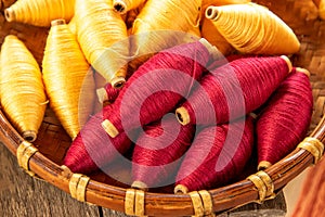 Natural colour of red and yellow cotton spools of thread use for weaving textile with tradition loom