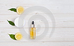 Natural cosmetic oil with lemons beautiful colse-up flat lay composition on the white wooden background