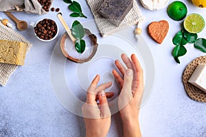 Natural cosmetic products setting with soaps and fresh herbs top view woman hands