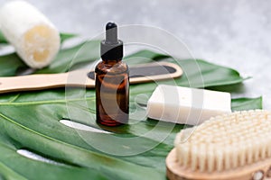 Natural cosmetics for bathing on the background of a palm leaf. Body moisturizing soap, serum and oil, loofah loofah and