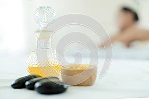 Natural cosmetics and concept. Close up of salt with massage oil and bath towel on Spa bed. Bottle of massage oil, hot stone spa