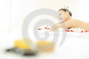 Natural cosmetics and concept. Close up of salt with massage oil and bath towel on Spa bed. Bottle of massage oil, hot stone spa