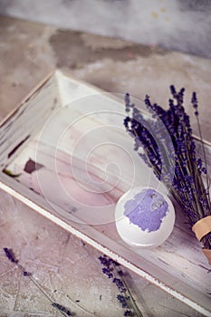 Natural cosmetics. Handmade lavender bath bombs, lavender flowers and towel on white wooden planks, top view