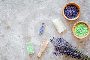 Natural cosmetics with lavender and herbs for homemade spa on stone background top view mock up