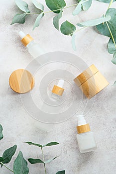 Natural cosmetics set on stone table with eucalyptus leaves. Flat lay, top view