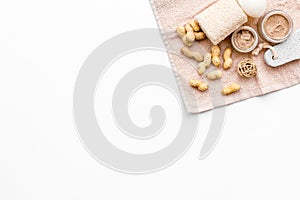 Natural cosmetics for skin care. Body scrub with peanut. White background top view copy space