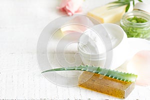 Natural cosmetics for skin care with petals rose and aloe vera on white planks