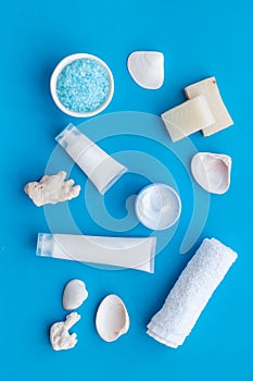 Natural cream, lotion, salt with Dead Sea minerals for homemade spa on blue background top view